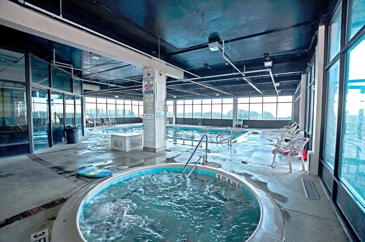 This interior pool and hot tub area, with large windows and comfortable seating, exudes a calming, resort-like atmosphere. It showcases indoor amenities available year-round, such as swimming, relaxing, or socializing, which are all mentioned as family-friendly activities.